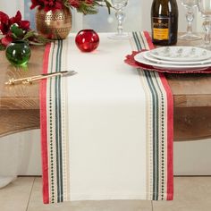 the table is set for christmas dinner with red and green decorations