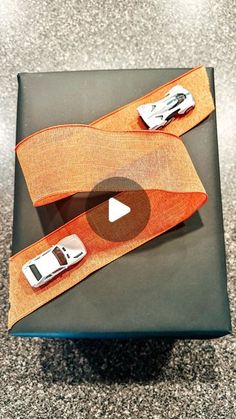 an orange belt with two cars on it