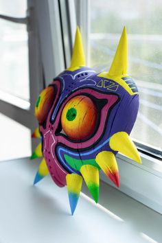 a colorful fish toy sitting on top of a window sill