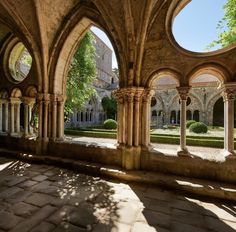 an old building with stone pillars and arches in the center, looking out onto a courtyard