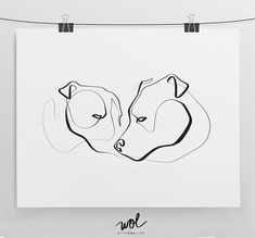 a black and white drawing of two dogs on a sheet of paper hanging from a clothes line