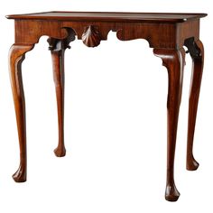 an antique wooden table with carved legs