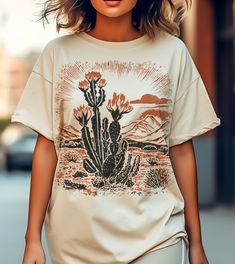 Desert vibes shirt, cactus tee shirt, Beauty of Desert tee, Wildflowers tee shirt,Cactus blooms flower t-shirt, Cottage Core shirt, camping  This classic unisex jersey short sleeve tee fits like a well-loved favorite. Soft cotton and quality print make users fall in love with it over and over again. These t-shirts have-ribbed knit collars to bolster shaping. The shoulders have taping for better fit over time. Dual side seams hold the garment's shape for longer.  .: 100% Airlume combed and ringspun cotton (fiber content may vary for different colors) .: Light fabric  .: Retail fit .: Tear away label .: Runs true to size SIZE  Unisex Style fro S-3XL PROCESSING TIME 1-7 business days (Depends on the Holidays and stock) PRINTING PROCESS Discover the future of eco-friendly printing with us! Our Spring Outdoor T-shirt With Letter Print, Casual Summer T-shirt For Outdoor, Casual T-shirt For Outdoor Summer Activities, Casual T-shirt For Spring Outdoor Activities, Casual T-shirt For Outdoor Spring Activities, Casual T-shirt For Outdoor Spring Events, Trendy Relaxed Fit T-shirt For Outdoor, Trendy Outdoor Relaxed Fit T-shirt, Casual Printed Outdoor Tops