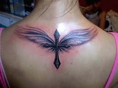 the back of a woman's neck with a cross and wings tattoo on it