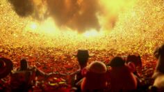 an image of people sitting on the ground in front of a fire pit with flames coming from it