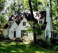 a white house surrounded by trees and grass