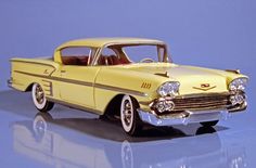 an old model yellow car on a reflective surface