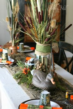 the table is set for thanksgiving dinner with turkeys and grasses in mason jars on it