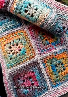 a crocheted blanket is laying on top of a chair with a flowered design