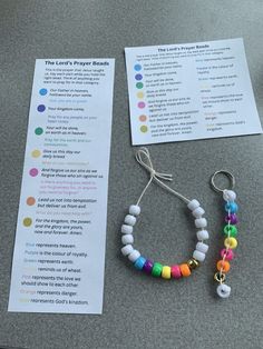 two bracelets are on the table next to a paper with instructions for prayer beads