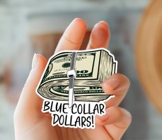 a person holding up a sticker with the words blue collar dollars written on it