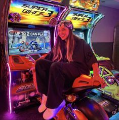 a woman sitting on top of a motorcycle next to slot machines