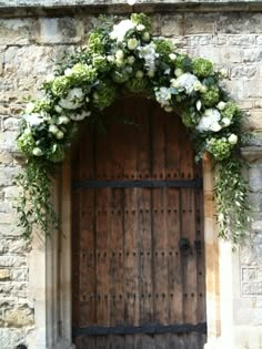 an old wooden door with white flowers on it