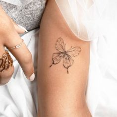 a woman's arm with a butterfly tattoo on the left side of her body