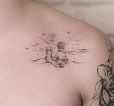 a man with a tattoo on his chest is sitting next to a cat and mouse