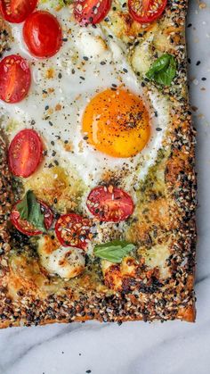 an egg and tomato pizza is shown on a sheet of parchment paper with sprinkles