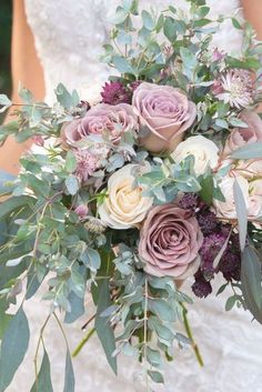 a bridal holding a bouquet of flowers and greenery