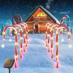 a christmas scene with candy canes in front of a house and snow covered ground