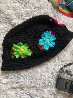 Look shagedelic in this groovy rainbow flower bucket hat🌈✨ Made with bright neon colored and black acrylic yarn. This hat fits average sized adult heads.MEASUREMENTS 23 inches around7 inches from crown to brim3 inch wide flower band1.25 inch wide brim6.5 inches across top of hatHand/gentle wash and air/tumble dry for best results.Do not bleach or iron.Message me about custom sizing and/or colors. Feel free to let me know your questions and concerns🌸 Black Crochet Yarn Hat, Fun Black Bucket Hat For Spring, Hippie Multicolor Spring Hat, Black Crochet Adjustable Hat, Black Retro Bucket Hat For Summer, Black Crochet Hat With Adjustable Fit, Black Crochet Hat Adjustable, Black Crochet Hat One Size Fits Most, Black Crochet Hat Adjustable Fit