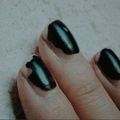 a woman's hand with black nail polish on it