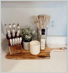 kitchen utensils are arranged on a cutting board in front of the counter top