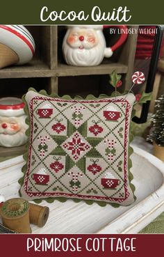 a christmas pillow sitting on top of a table next to other ornaments and decor items