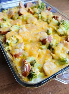 a casserole dish with broccoli, ham and cheese in it on a wooden table