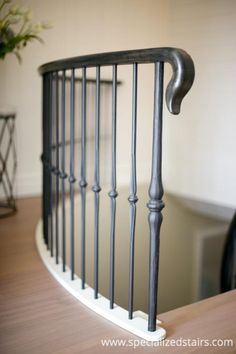 an iron hand rail on top of a wooden table next to a potted plant