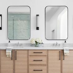 a bathroom with two sinks and three mirrors on the wall next to eachother