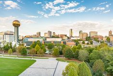 an aerial view of a city with trees, buildings and a tennis court in the foreground