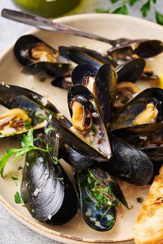 a plate full of mussels and bread on a table