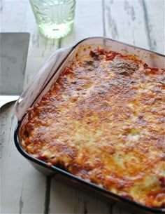 a casserole dish on a table with a knife and fork next to it