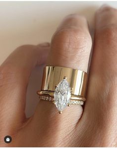 a woman's hand with two gold rings and a diamond ring on her finger