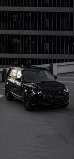 a black suv parked in front of a tall building