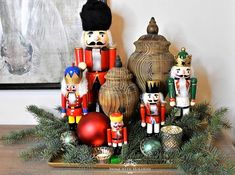 nutcrackers and ornaments are on display in front of a painting