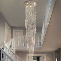 a living room filled with furniture and a chandelier hanging over the top of it