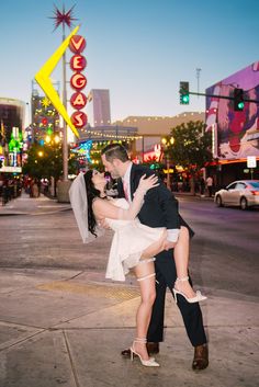 a bride and groom kissing on the street in las vegas, nv at night