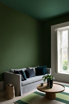 a living room with green walls and white trim