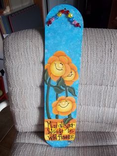 a painted skateboard sitting on top of a chair