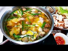 a pan filled with lots of food on top of a stove next to other dishes