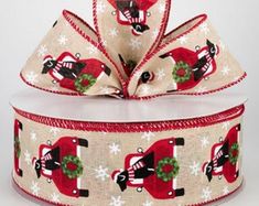 a christmas themed ribbon with santa claus and snowflakes on the bottom, tied to a white box