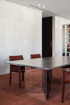 a large table with chairs around it in a room that has red carpet on the floor