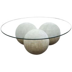 three white balls sitting on top of a glass table