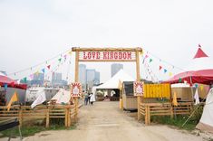 an entrance to a festival with tents and flags