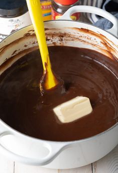 a yellow spatula is being used to dip chocolate into the batter in a pan