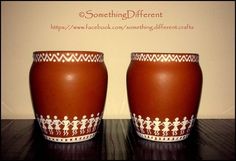 two brown vases sitting on top of a wooden table