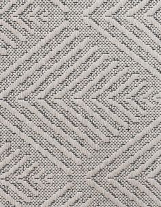 a close up view of a white and grey rug with diamond shapes on it's surface