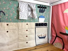 a kitchen area with an oven, cabinets and wallpaper