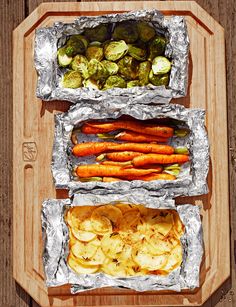 three trays filled with different types of food on top of a wooden table next to each other