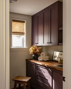 a kitchen with dark wood cabinets and white walls